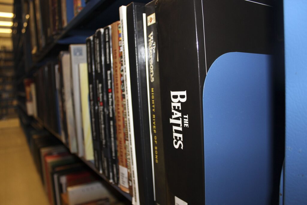 Coffret de disques compacts ouvert, pochettes cartonnées empilées à côté du boîtier