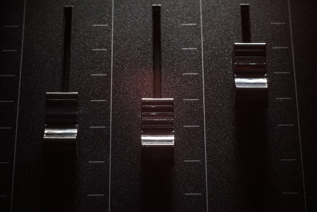 Console de mixage avec ses rang&eacute;es de curseurs et de potentiom&egrave;tres vue en plong&eacute;e