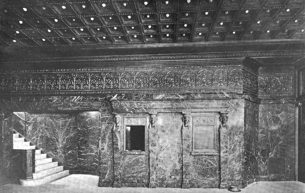 Guichet de billetterie d'une salle de spectacle avec sa vitre et son comptoir en bois