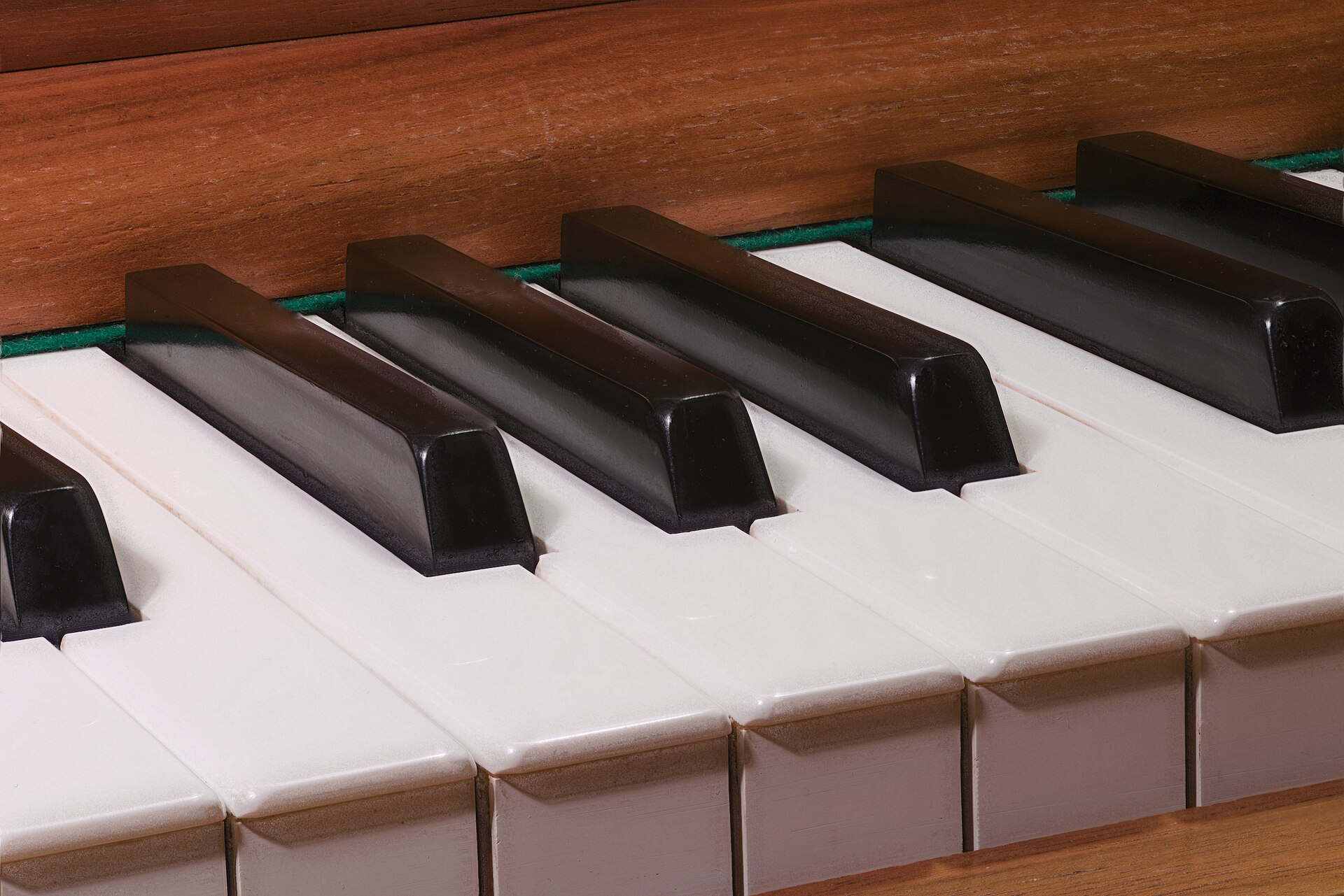 Métronome mécanique en bois posé sur un piano, à côté d'une partition ouverte