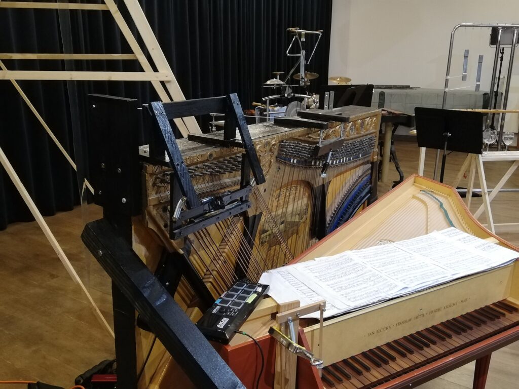 Cordes d'un piano &agrave; queue pr&eacute;par&eacute;es avec des objets gliss&eacute;s entre elles, couvercle relev&eacute;
