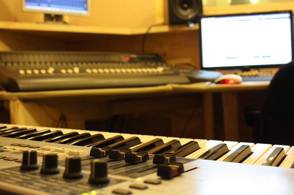 Deux enceintes de contrôle posées de part et d'autre d'un bureau de montage audio