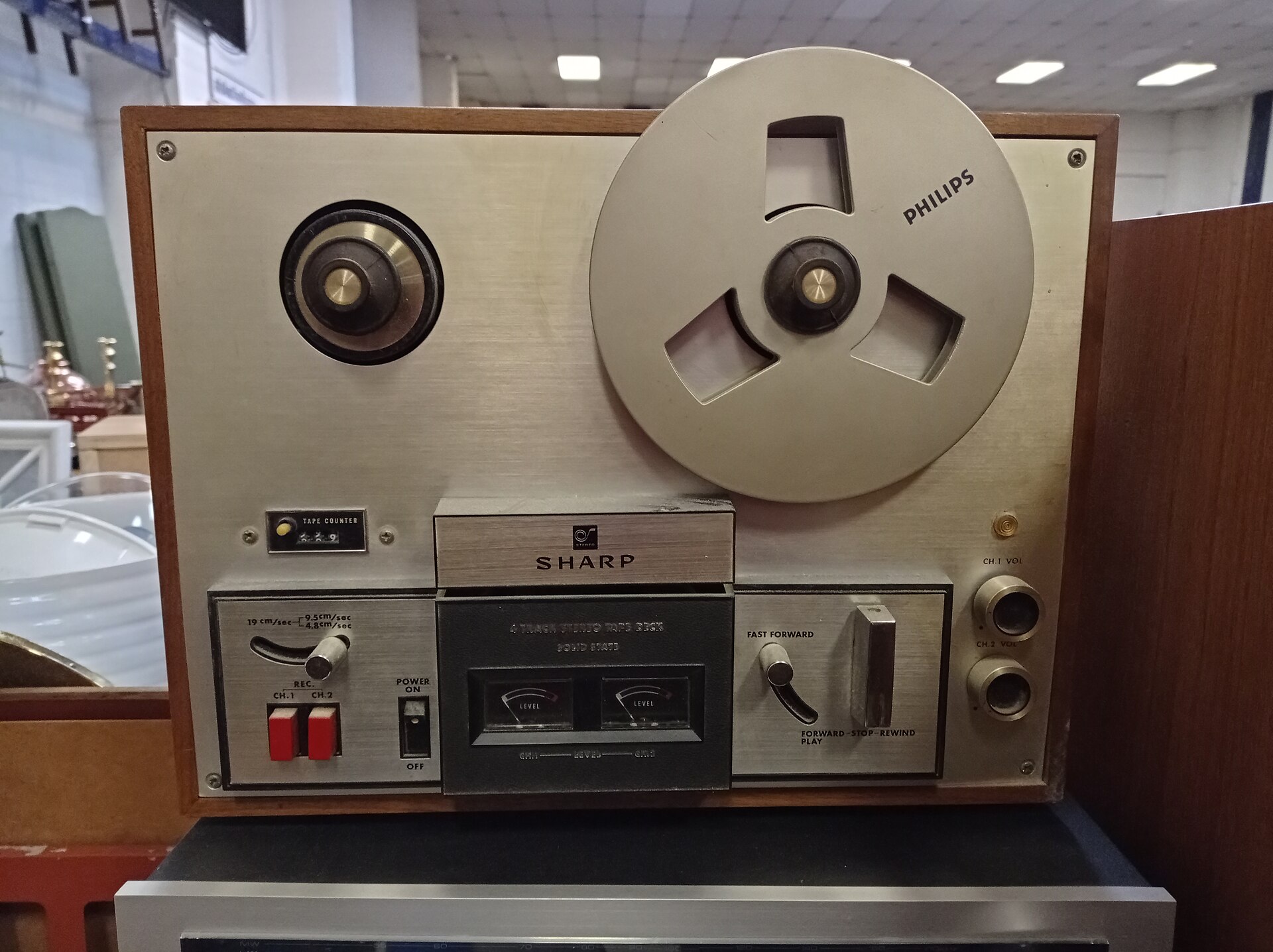 Magnétophone à bandes avec deux bobines en place, têtes de lecture visibles au centre