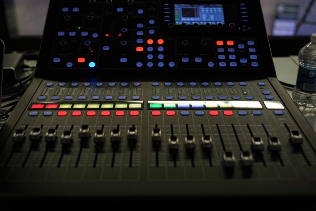 Console de mixage utilisée pour une captation live, curseurs et boutons éclairés