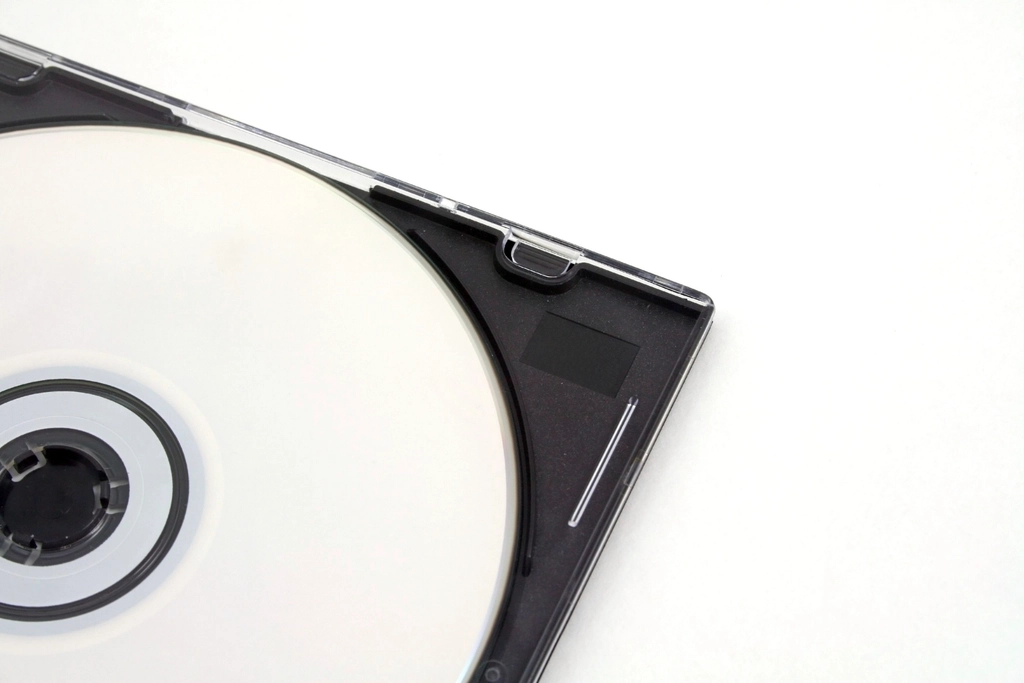 Boîtier de disque compact posé sur une table, pochette sobre et livret glissé à côté